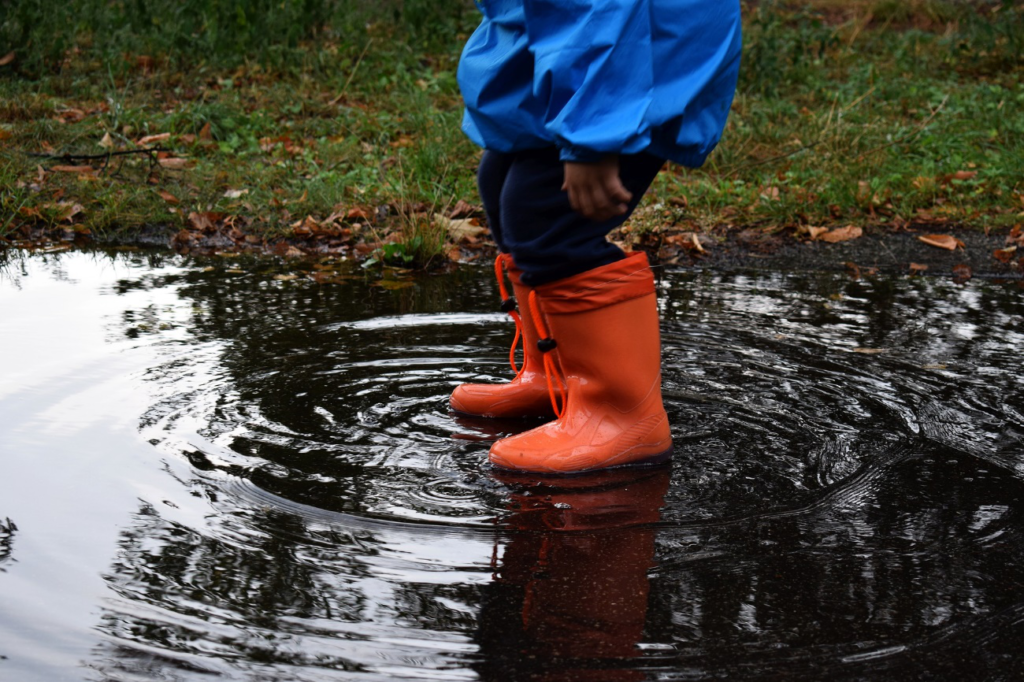 長靴で水たまりに入る子供